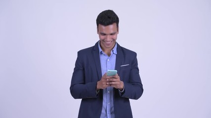 Wall Mural - Happy young Indian businessman using phone