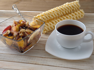 Wall Mural - Breakfast.Fruit salad.Black coffee and croissant.On a wooden tray