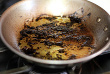 Leftover Grease And Char On A Stainless Steel Pan After Cooking.