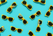 © aanbetta - Flat lay pattern yellow sunglasses on blue background. Summer concept. 3d rendering