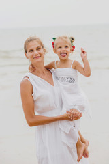 Wall Mural - Happy mother and baby on the sunset at the beach.