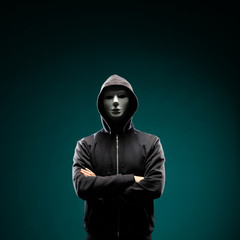 Wall Mural - Computer hacker in white mask and hoodie. Obscured dark face. Data thief, internet fraud, darknet and cyber security concept.