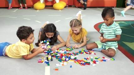 Wall Mural - Group of kids playing with block toys. Children playing together with colorful plastic toy constructor in playroom. Spend time with pleasure.