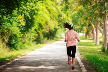 Back side of Young sporty woman runner running in park, female in sport cloth jogging at park,healthy active lifestyle concept