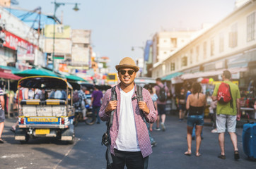 Young asian traveller man walking in Khaosan Road walking street in bangkok thailand on vacation time.