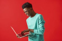 Young African American Man Standing With Laptop And Smiling