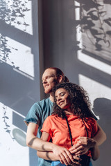 Happy guy is embracing beloved girl indoors