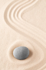 Wall Mural - Zen garden meditation stone. Round rock on sandy texture background. Yoga or mindfulness concept.