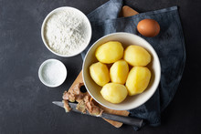 Сoncept Of Cooking Potatoes. Flour, Salt, Egg And Boiled Potatoes On A Dark Background.