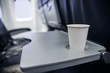 © Alex J - plastic cup on the table in the plane during the flight. alcohol consumption on board
