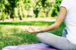 © My Ocean studio - Morning yoga. Healthy lifestyle. Cropped photo of young slim woman in exercise clothes while she sitting in lotus position on yoga mat.
