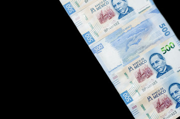 Mexican money on black background