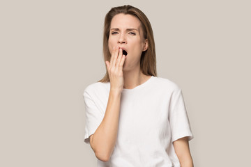 tired sleepy young woman yawning, covering mouth with hand