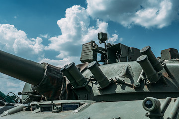 Close-up of part of old military tank with tower against blue sky