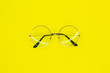 © Olga - Round glasses on yellow background. Fashion accessory for a clear view.