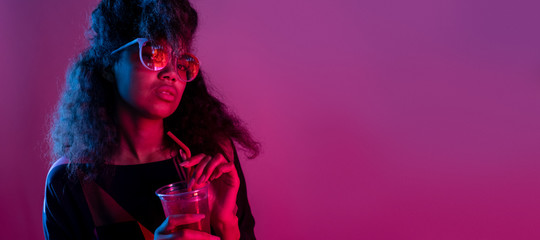fashion young african girl black woman wear stylish pink glasses holding drink looking at camera iso