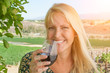 Beautiful Young Adult Woman Enjoying Glass of Wine Tasting In The Vineyard