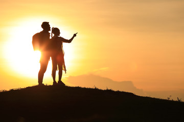 Wall Mural - The silhouette of a lover, holding hands on the hills,