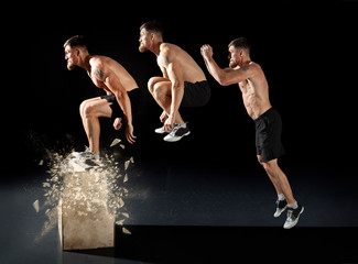 Wall Mural - Sporty man jumping on box training at the gym