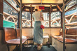 © YiuCheung - Woman wearing straw hat stand on tram in Hong Kong