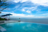 Fototapeta Most - Pattaya, Thailand Luxury - June 3, 2019: swimming pool and blue water at the resort with beautiful sea view at u jomtien pattaya. Seaside pool