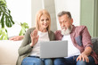 © Pixel-Shot - Happy elderly couple with laptop resting at home