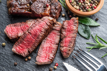 Wall Mural - Medium rare Ribeye steak with herbs on graphite board.