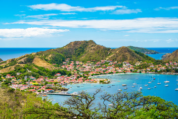Fototapete - Terre-de-Haut, Guadeloupe.  Colorful landscape with village, bay and mountains.