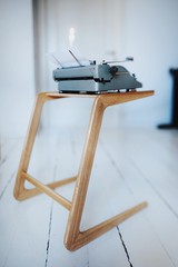 Wall Mural - Wood minimalistic coffee table with vintage typewriter in white interior