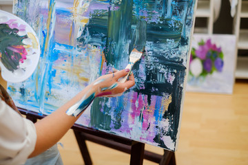 Creative painter paints a colorful picture in her studio