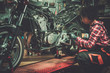 © Nejron Photo - African american woman mechanic repairing a motorcycle in a workshop