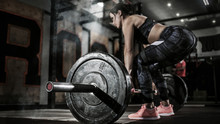 Sport. Muscular Women Lifting Deadlift In The Gym With Barbell. Dramatic Interior With Smoke.