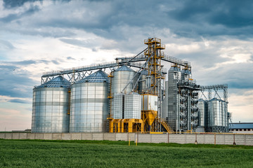 Wall Mural - agro-processing plant for processing and silos for drying cleaning and storage of agricultural products, flour, cereals and grain with beautiful clouds