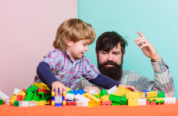 happy little boy with bearded man dad playing together. father and son play game. building home with colorful constructor. happy child development. happy family. leisure time. feeling happy