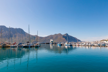 Wall Mural - Hout Bay boats and mountain reflections morning view