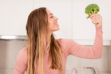 Attractive woman holding fresh raw broccoli