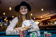 © RomanR - Happy woman in casino with poker chips and cards