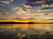 Beautiful yellow and orange sunset with dramatic clouds & crepuscular rays reflected in calm water of Hayward WI. Concepts of vacation, travel, holidays