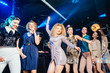 © Iryna - Young people having fun at party in night club. Stylish sexy bridesmaids having fun with bride standing in a row celebrating at party in night club.. Girls celebrate a bachelorette party of bride.