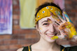 © golubovy - Talent and leisure. Closeup portrait of young female artist having fun in studio, smiling, showing hand dirty with paint.