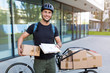 © pikselstock - Bicycle messenger making a delivery on a cargo bike