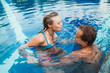 © Helene Cyr Photography/Stocksy - Couple playing in a pool