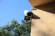 Kamera monitoringu z reflektorem led i czujnikiem ruchu na ścianie budynku.