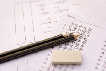 Pencil and eraser on answer sheets or Standardized test form with answers bubbled. multiple choice answer sheet .