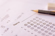 © Achira22 - Pencil and eraser on answer sheets or Standardized test form with answers bubbled. multiple choice answer sheet .