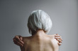 © Rob and Julia Campbell/Stocksy - Senior topless woman on simple grey background