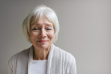 Studio Portrait Of Senior Woman On Simple Grey Background