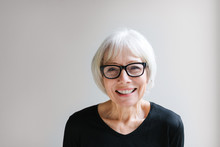 Studio Portrait Of Senior Woman On Simple Grey Background