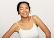 © leandro crespi/Stocksy - Young natural asian woman portrait applying moisturiser.
