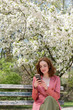 © jamie grill photography/Stocksy - Woman in park looking at phone